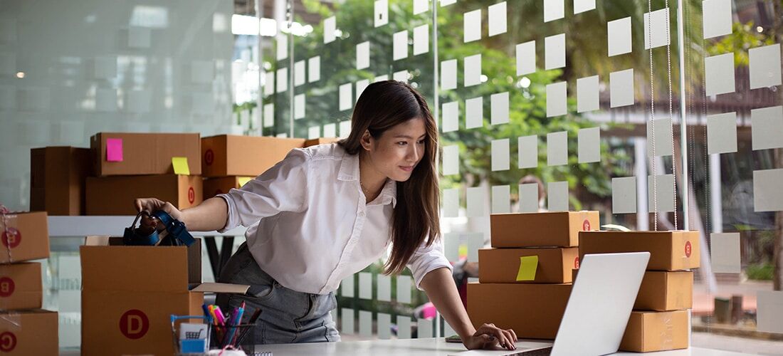 Owner of Online Business A small business owner checking online orders to prepare to pack the boxes for customers