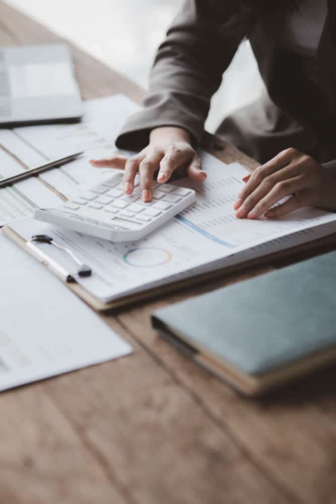 Business person calculating numbers from financial documents Business person calculating numbers from financial documents