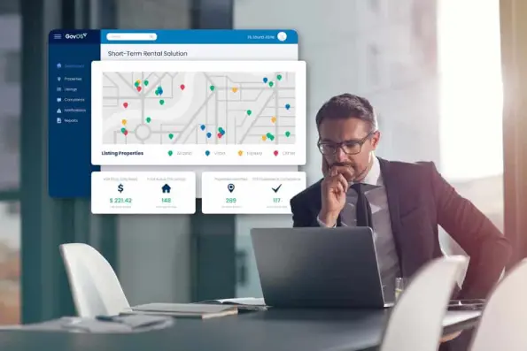 Office employee looking at a short-term rental dashboard on his laptop.
