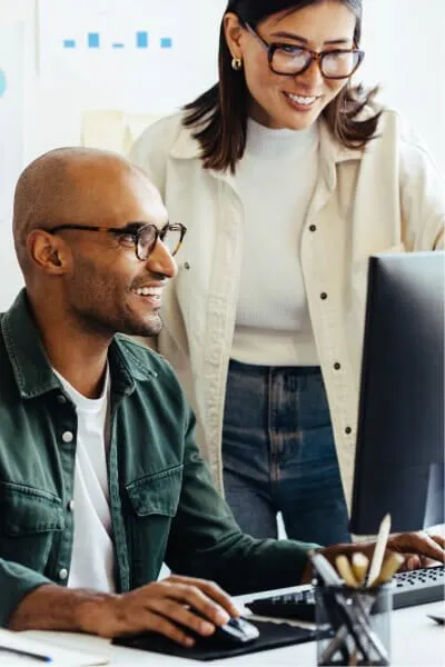 Two co-workers looking at a monitor