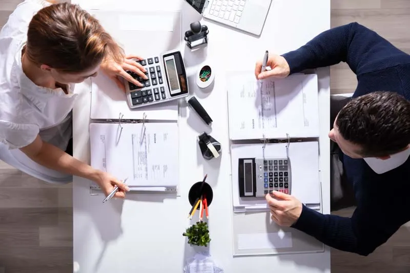 Two people working at a desk. Two people working at a desk.
