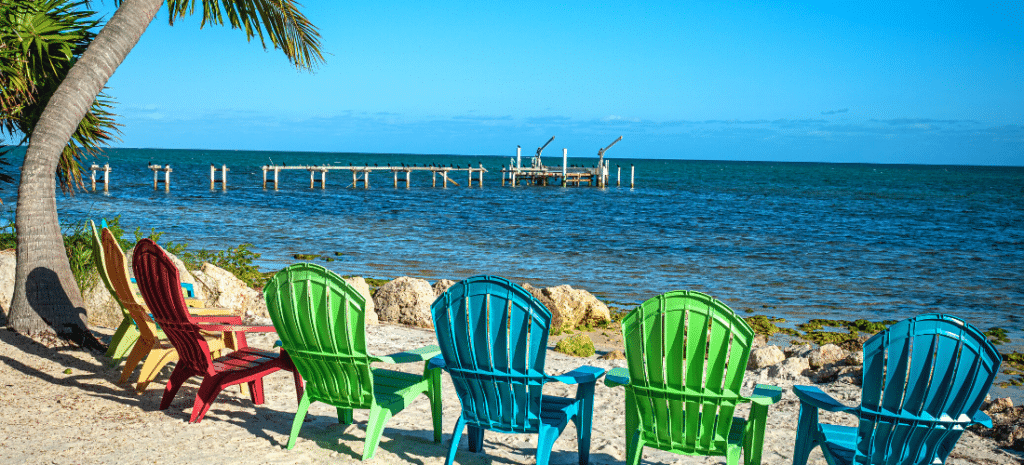 Colorful-beach-chairs-lined-up-in-sand-along-ocean-in-Florida-Keys