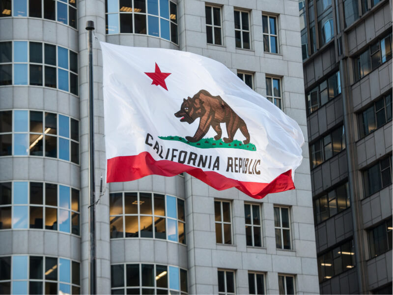 California flag in front of downtown buildings California flag in front of downtown buildings